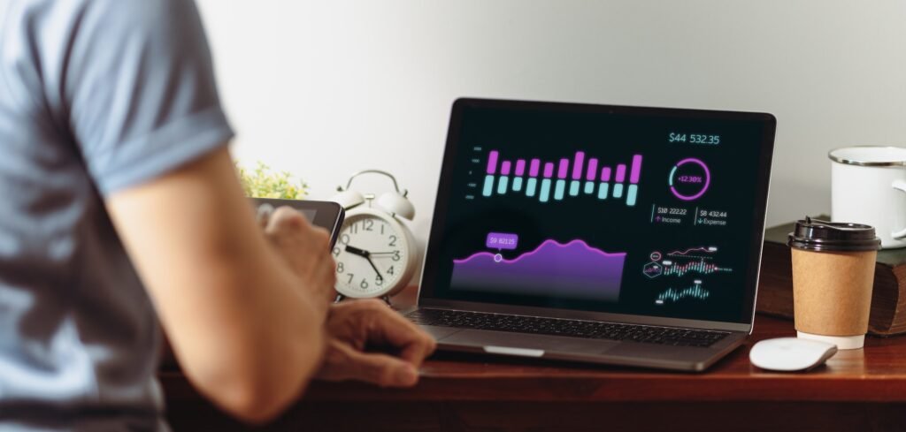 A company graph and financial data analysis are displayed on a laptop computer